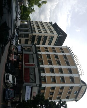 A multi-story hotel with a modern architectural design, featuring a prominent entrance with a red awning and a visible Star Hotel sign. - First and New Star Hotel (Kuala Lumpur)