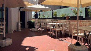 An outdoor patio with tables and chairs, umbrellas, and potted plants. - Hanna Hotel (Istanbul)