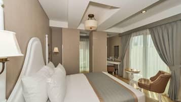 A hotel room with a large bed, a desk, a chair, and a bathroom visible through a glass door.