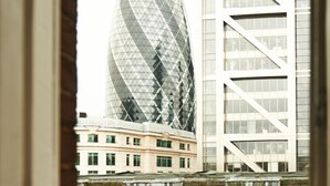 A view of a modern building with a distinctive diamond-patterned facade through a window. - The Bull and The Hide (London)