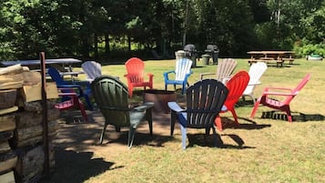 An outdoor seating area with Adirondack chairs and picnic tables.