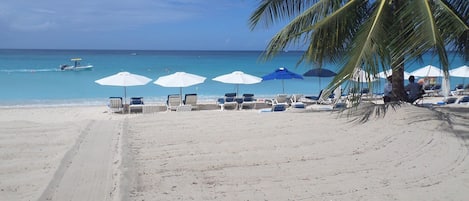 On the beach, white sand, sun-loungers, beach towels