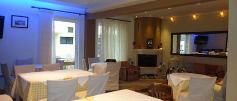 Habitación de hotel con comedor, chimenea y televisión.