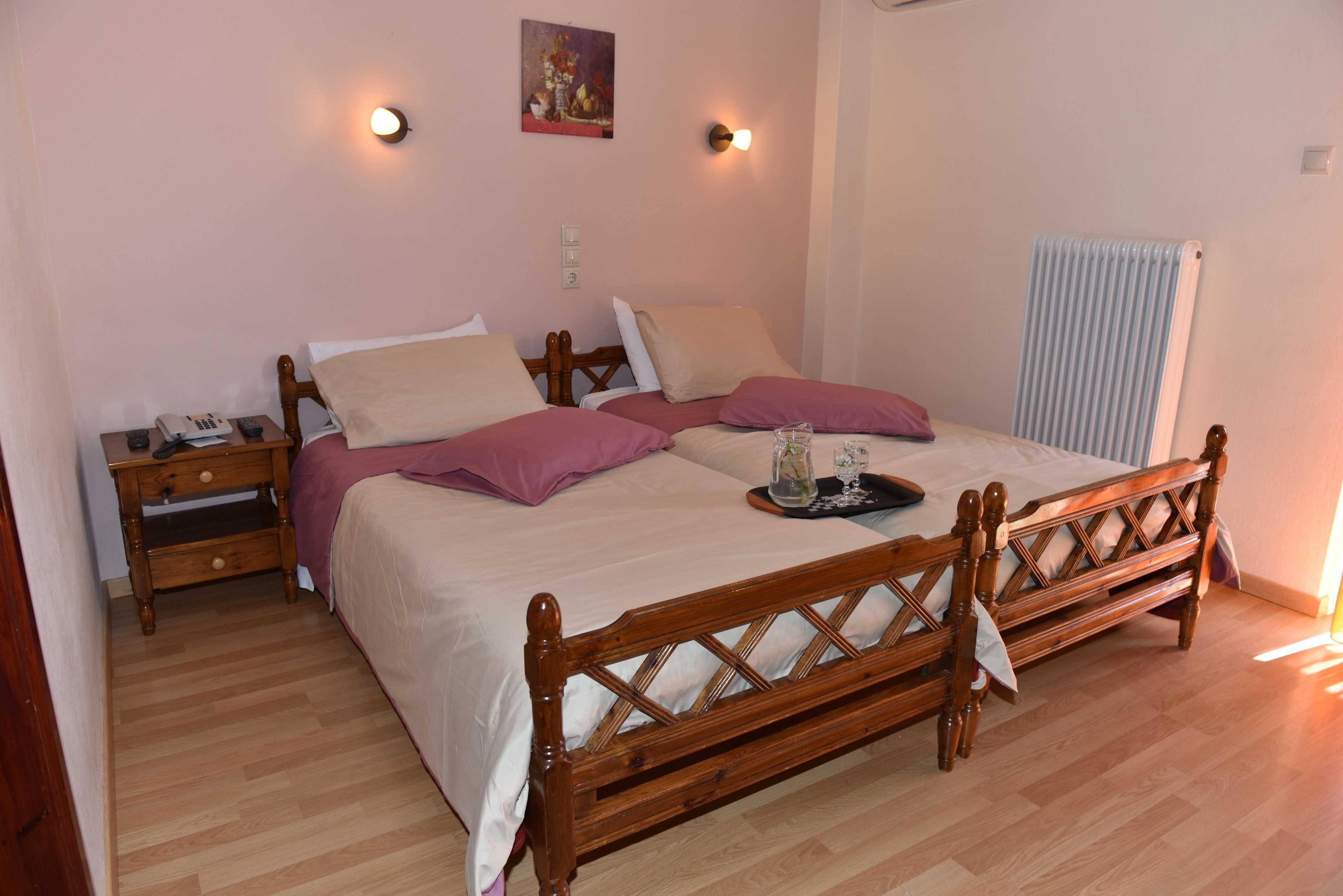 Un dormitorio con cama de madera, mesitas de noche y un radiador.