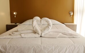 A hotel room with a bed, a nightstand, and a wall-mounted lamp. - Embajada Wanka (El Tambo)