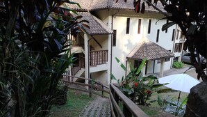 A staircase leading to a building with a tiled roof and a balcony. - Pousada 3 Bacias (Resende)