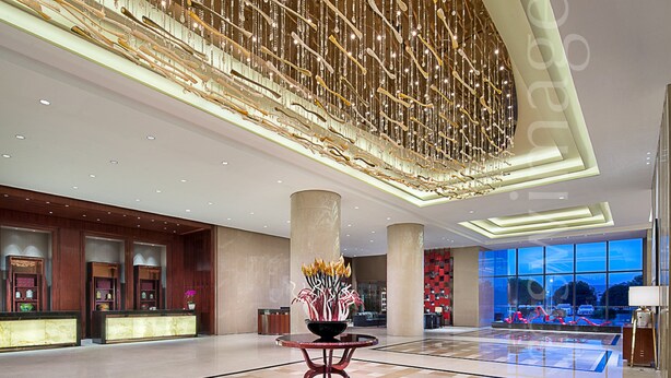 A spacious lobby with a high ceiling, a central round table with a floral arrangement, and a reception desk. - Xiandai Gloria Grand Hotel Changsha (Changsha)