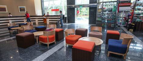 A lobby with seating areas, a reception desk, and a pharmacy.