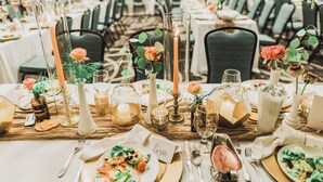 A banquet hall with round tables set for a formal event, featuring name cards, candles, and floral centerpieces. - Holiday Inn & Suites Peoria At Grand Prairie by IHG (Peoria)