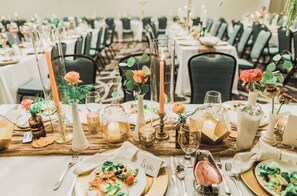 A banquet hall with round tables set for a formal event, featuring name cards, candles, and floral centerpieces. - Holiday Inn & Suites Peoria At Grand Prairie by IHG (Peoria)