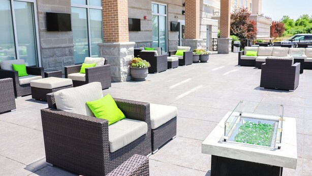 An outdoor seating area with wicker furniture and potted plants. - Holiday Inn & Suites Peoria At Grand Prairie by IHG (Peoria)