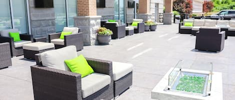 Un espace extérieur aménagé avec des meubles en osier et des plantes en pot.