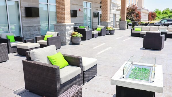 An outdoor seating area with wicker furniture and potted plants. - Holiday Inn & Suites Peoria At Grand Prairie by IHG (Peoria)