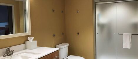 Une salle de bain moderne avec un lavabo, des toilettes et une douche à parois de verre.