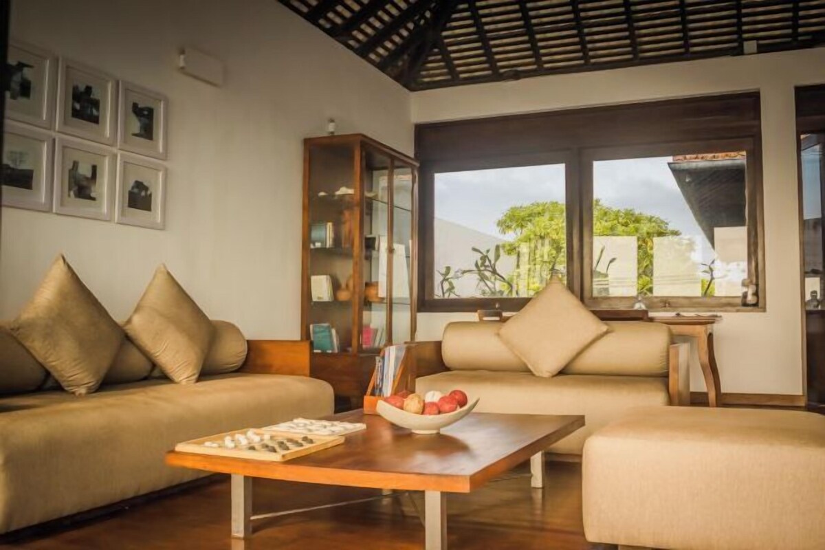 A modern living room with a sofa, a coffee table, and a bookshelf.