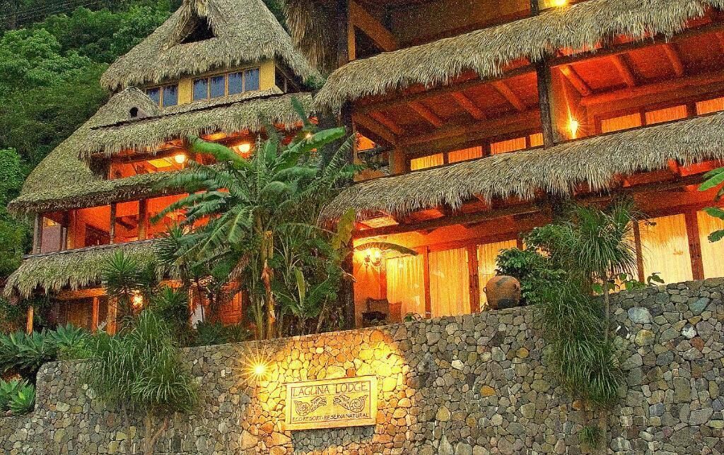 A multi-story building with thatched roofs and stone walls, labeled "Laguna Lodge."