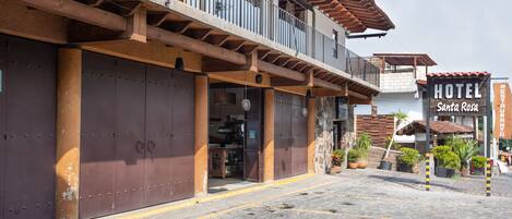 A hotel with a balcony, large metal doors, and a sign reading "HOTEL Santa Rosa."