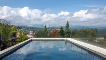 Piscina a l'aire lliure, para-sols i gandules