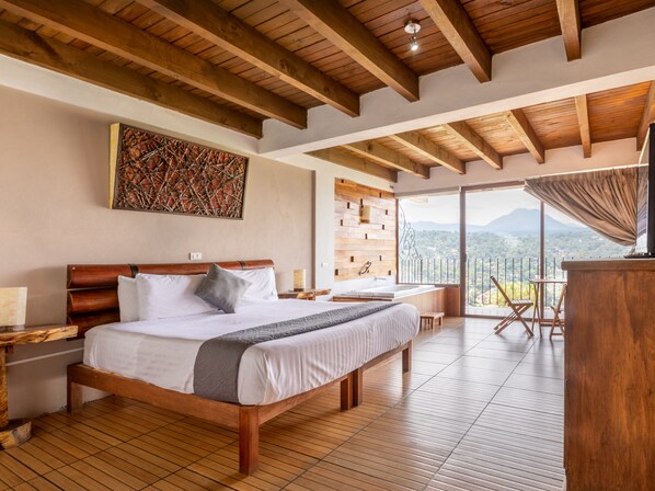 A spacious bedroom with a large bed, wooden beams, a view balcony, and a rustic wall design.