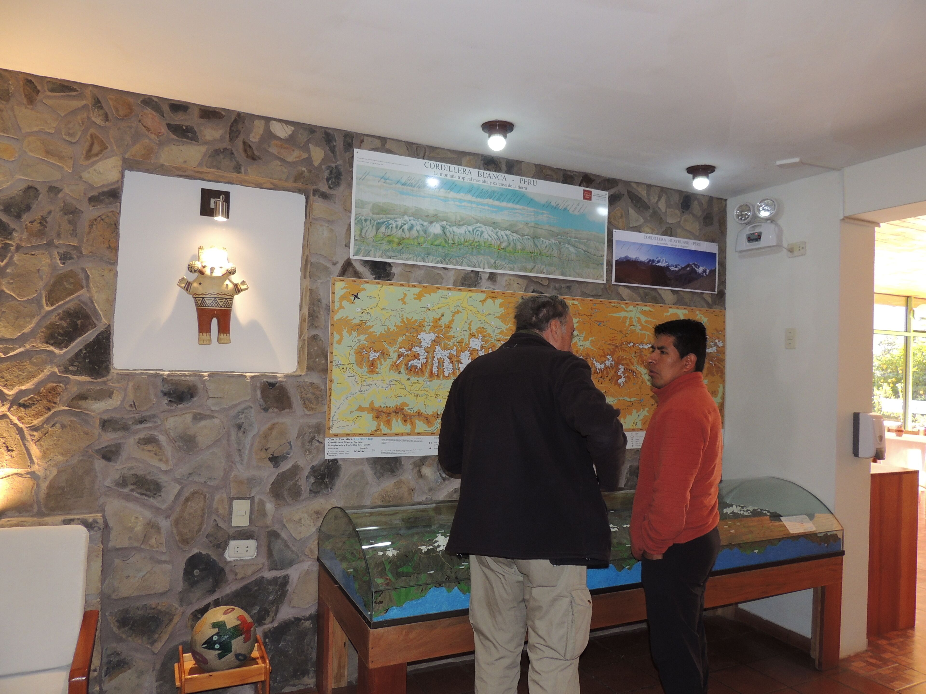 A stone wall with a map and a glass display case.