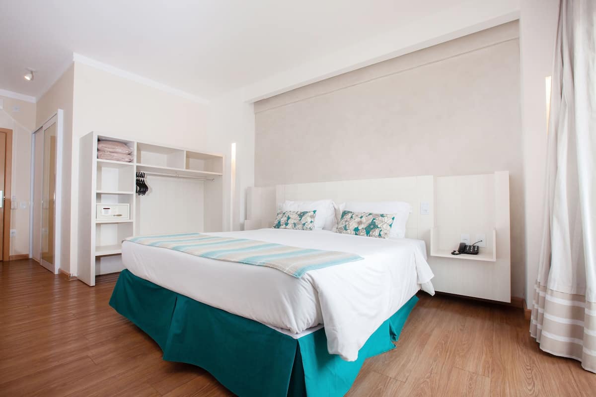 A bedroom with a bed, a wardrobe, and a bedside table.