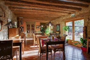 Enjoy meals in this charming dining area with natural and wicker furniture, a door leading to the outdoors, and a view through the glass door.