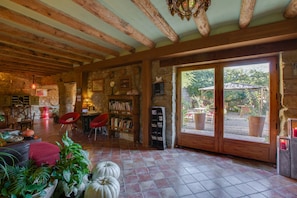 Relax in a cozy seating area with a comfortable chair and sofa, surrounded by books and a view of the outdoors.