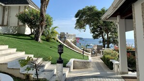 Un chemin menant à un bâtiment d’où l’on a une vue sur la mer.
