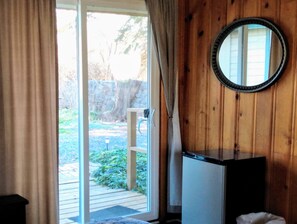 A room with a sliding glass door leading to an outdoor area, a small table, and a mirror on the wall. - Billingsley Creek (Hagerman)