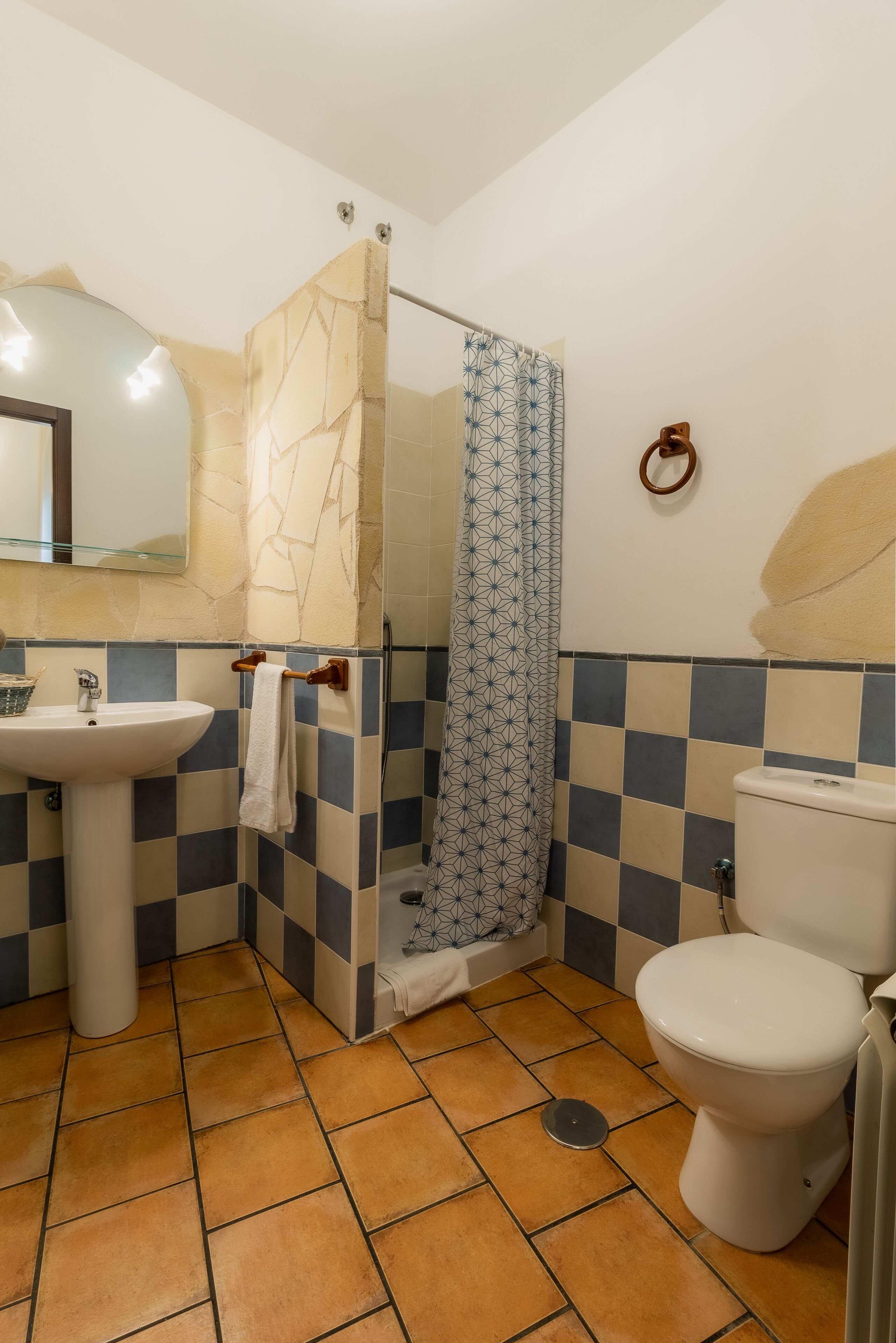 Un baño con lavamanos, inodoro y ducha.