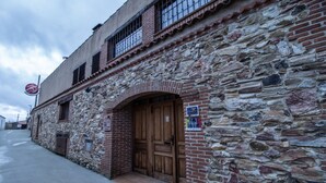A stone building with a wooden door and a sign for 'TRINO'. - Hotel Rural VII Carreras by Vivere Stays (San Pedro de Rozados)