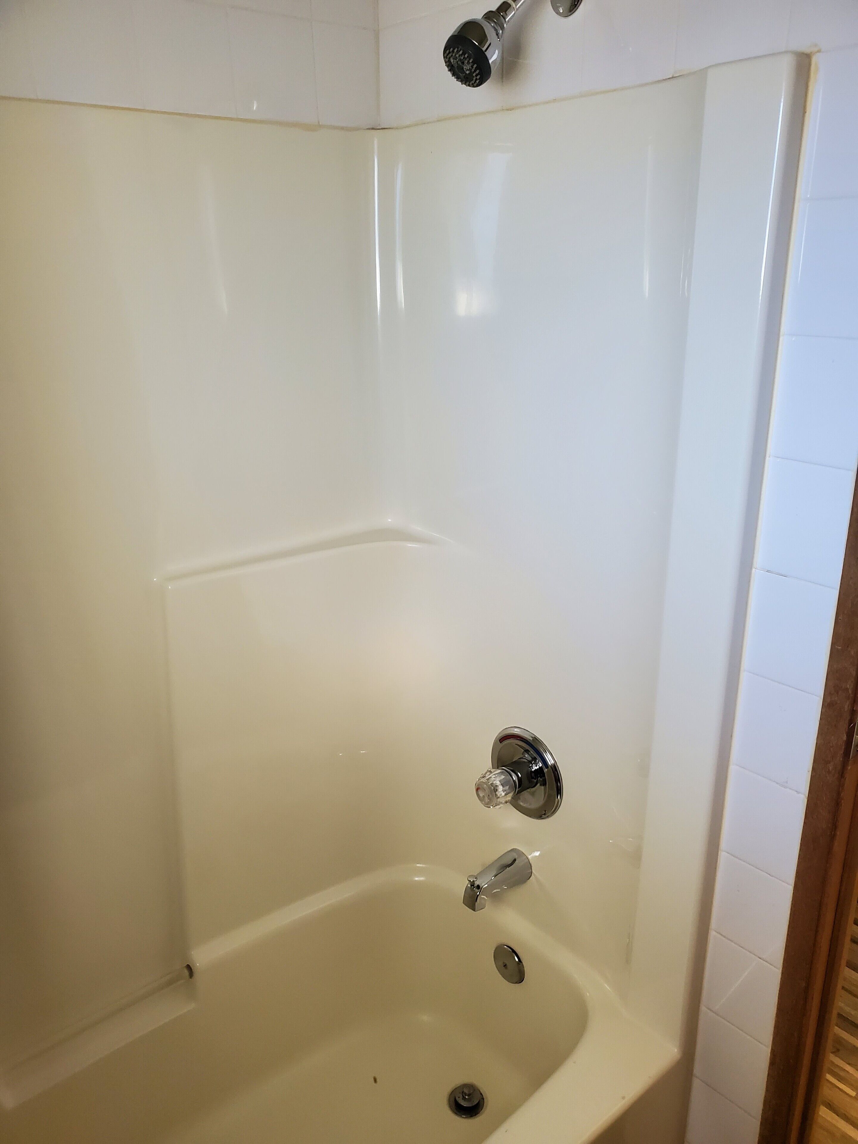 A white bathtub with a showerhead and a faucet.