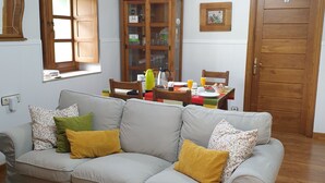 A living room with a sofa, a wooden coffee table, a dining table with chairs, and a cabinet. - La Pumarada de Limés (Cangas del Narcea)