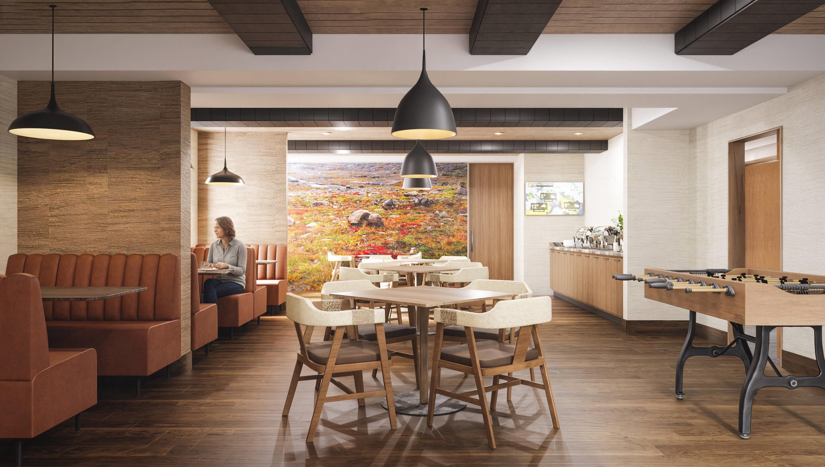 A restaurant with wooden flooring, a central dining table, and booths.