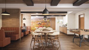 A restaurant with wooden flooring, a central dining table, and booths. - Clarion Pointe (Sept-Iles)