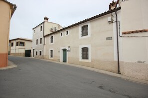 Eine enge Straße gesäumt von Gebäuden, darunter ein Gebäude mit der Aufschrift 'Calle Caballero'.