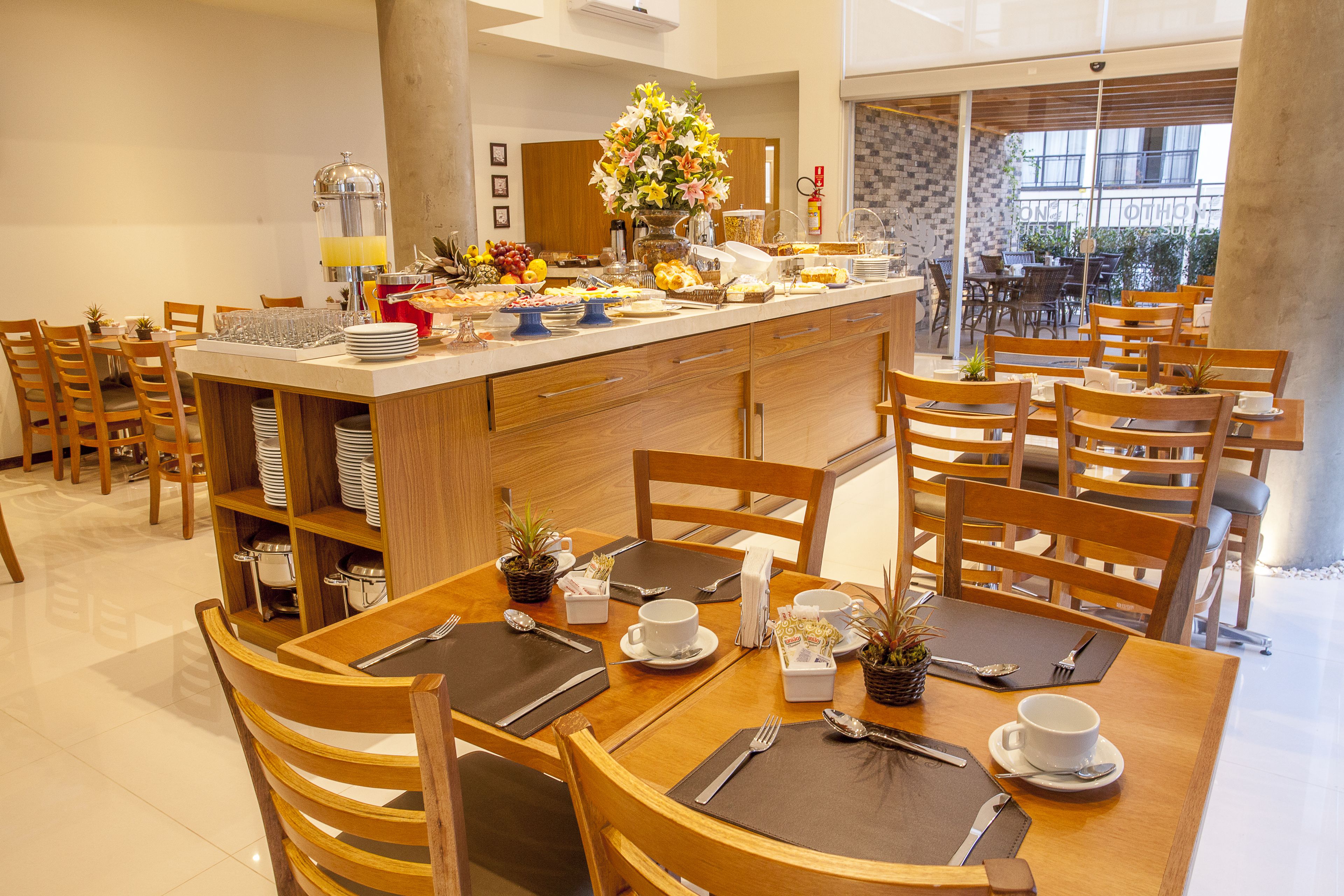 Un buffet de petit-déjeuner proposant une variété d’aliments et agrémenté d’un arrangement floral en guise de décoration centrale.