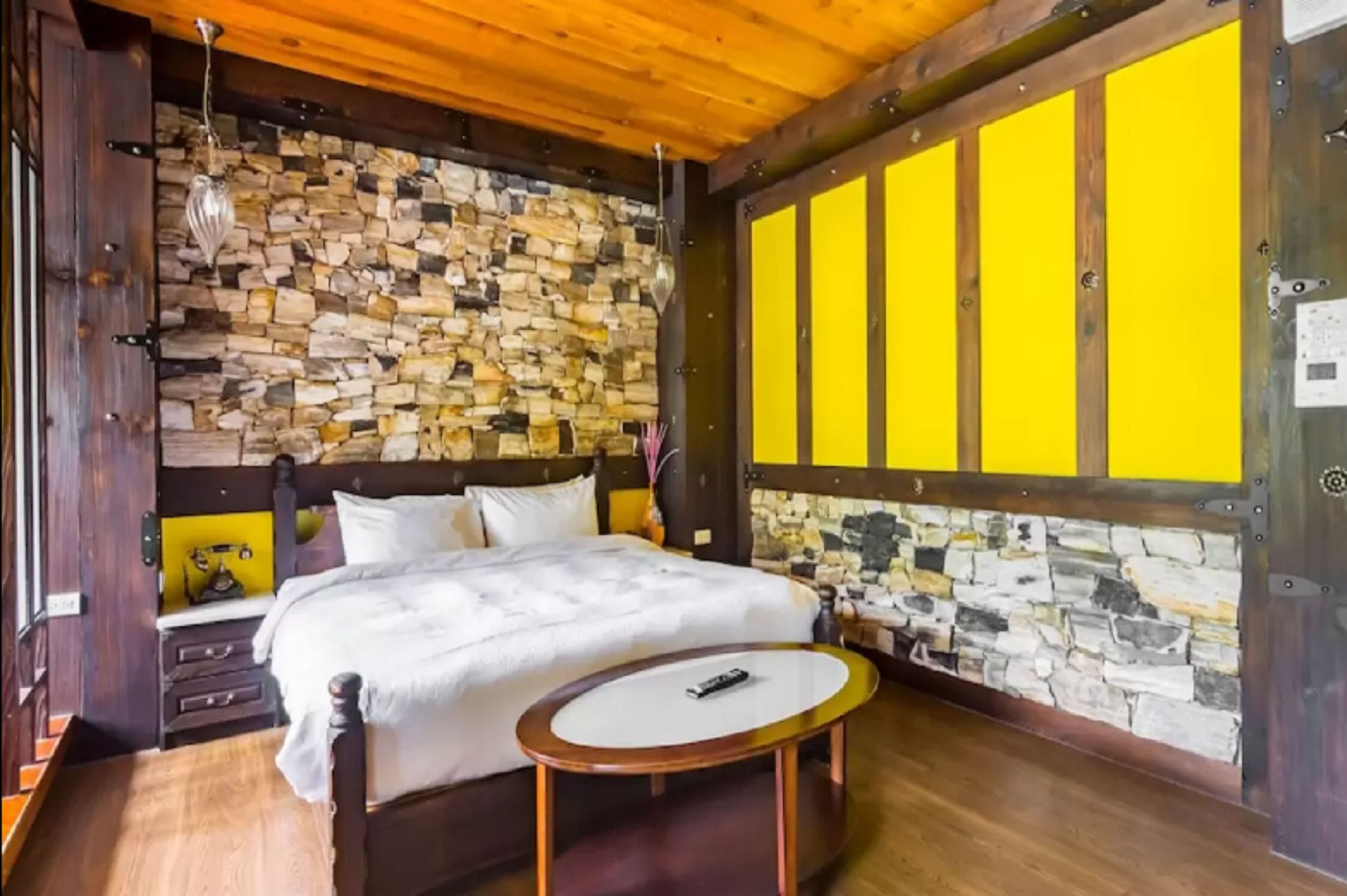 Ein Schlafzimmer mit Stewand, einem Bett, einem Nachttisch und einem runden Tisch.