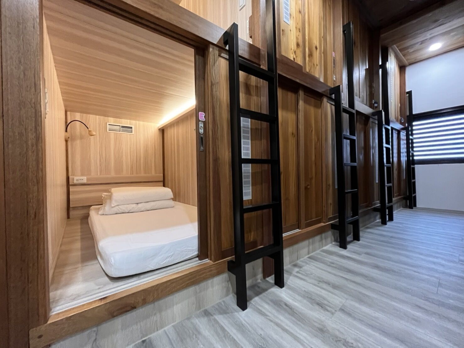 A room with bunk beds, a ladder, and a wooden wall.