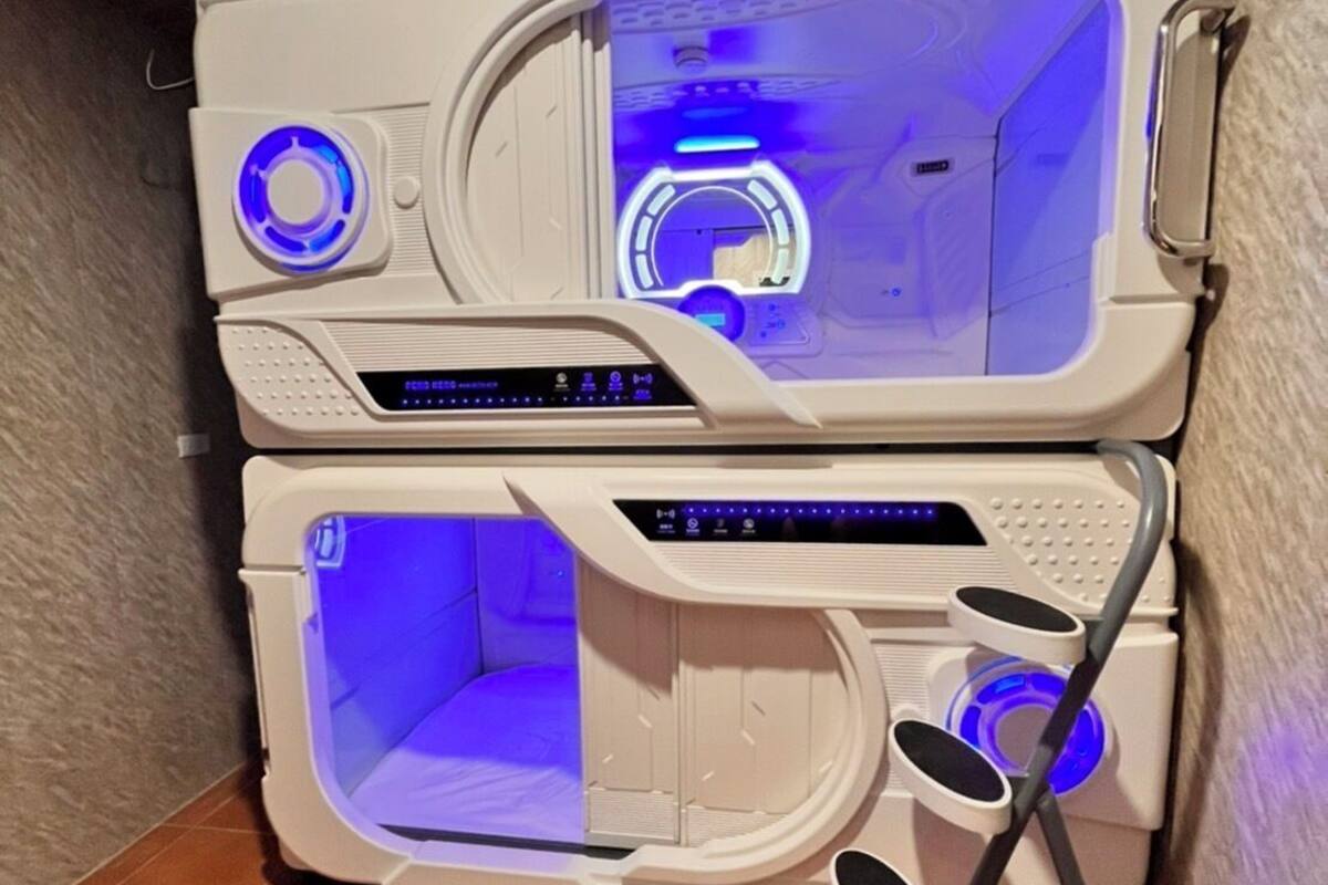 Un cuarto de spa con dos unidades separadas para masajes, cada una con un panel de control y luces azules iluminadas.