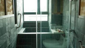 A bathroom with a glass-enclosed shower, a bathtub, and a toilet.