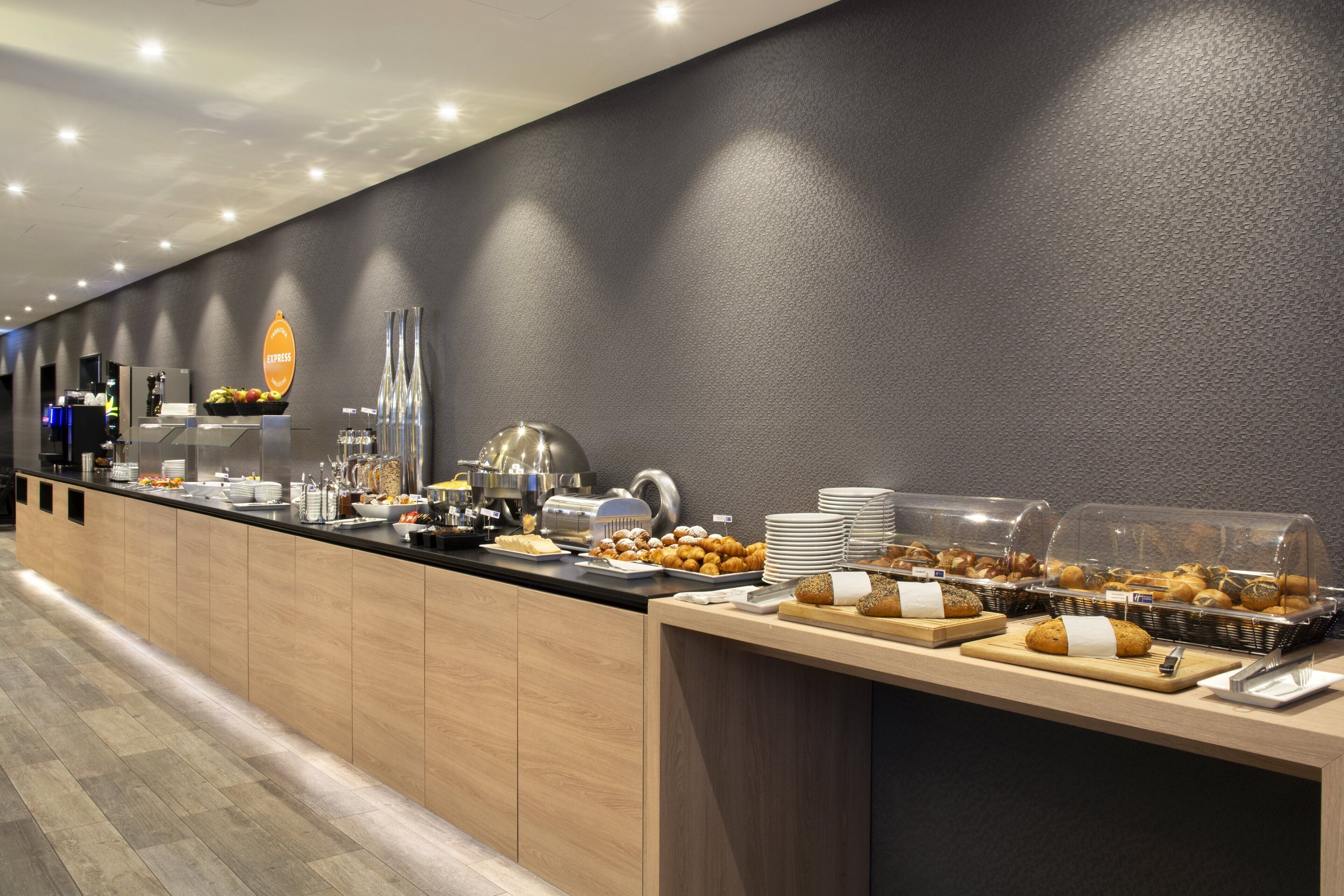 A long buffet counter with various food items and a coffee station.