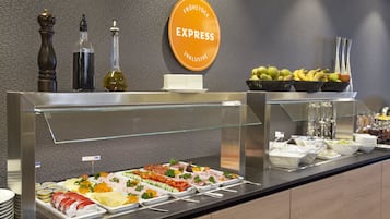 Ein reichhaltiges Buffet mit verschiedenen Speisen, darunter Fleisch, Käse und Obst.