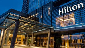 A modern hotel entrance with a glass facade and the name 'Hilton' prominently displayed. - Hilton Wuhan Riverside (Wuhan)