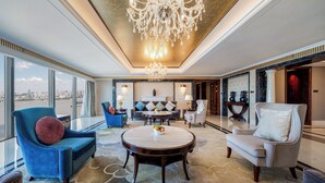 A spacious living room with a large chandelier, comfortable seating, and a view of the city. - Hilton Wuhan Riverside (Wuhan)