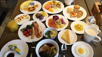 A breakfast buffet with various dishes including eggs, pastries, and fruit.