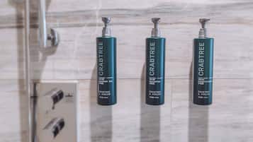 Three bottles of Crabtree & Evelyn's products on a tiled wall.