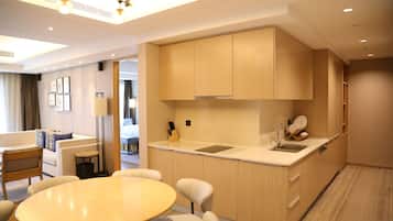 Una cocina moderna con armarios de madera, un fregadero y un comedor con mesa y sillas.