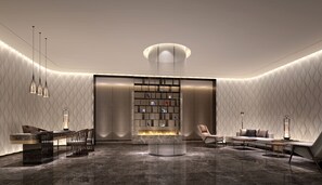 A modern lobby with a central fireplace, seating area, and a patterned wall design.