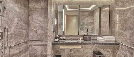 Een moderne badkamer met een grote spiegel, twee wasbakken en een douchehoek.